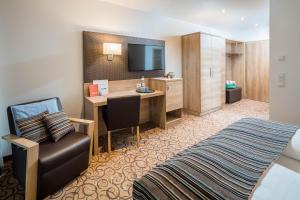 韋爾特湖畔費爾登的住宿－Seehotel Das JO，酒店客房设有一间带书桌和床的卧室