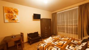 um quarto de hotel com uma cama e uma cadeira em Hotel Gran Aurum em La Paz
