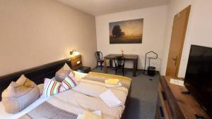 ein Hotelzimmer mit einem Bett und einem Tisch in der Unterkunft Pension & Gasthof "Am Park" UG in Stützerbach