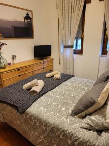 a bedroom with a bed with two towels on it at Villa Sabina "Vivienda de Uso Turístico" in Caboalles de Abajo