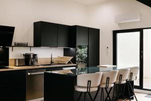 a kitchen with black cabinets and a glass table at Avenue Ferry in Libourne