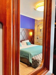 a bedroom with a bed in the reflection of a mirror at Hotel Solun in Trieste