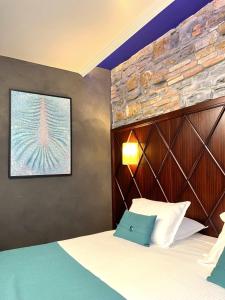 a bedroom with a bed with a brick wall at Hotel Solun in Trieste