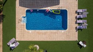 una vista aérea de una piscina con tumbonas y una piscina en Dene Hollow en Voroklini