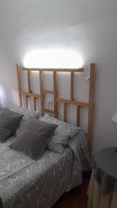 1 dormitorio con 1 cama con luz en la pared en Villa Sabina "Vivienda de Uso Turístico", en Caboalles de Abajo