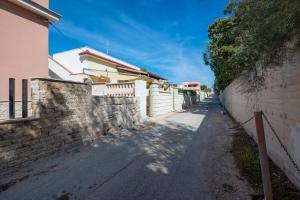 een straat naast een stenen muur en een hek bij Appartamento Acquadolce in Torre Ovo