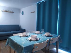 une table avec un chiffon de table bleu, des assiettes et des verres dans l'établissement studio 21, à Rochefort