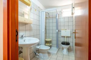 een badkamer met een wastafel, een toilet en een douche bij Appartamento Acquadolce in Torre Ovo