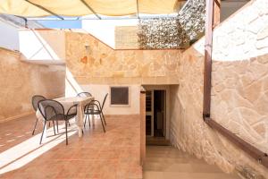 een kamer met een tafel en stoelen en een stenen muur bij Appartamento Acquadolce in Torre Ovo