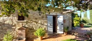 uma casa de pedra com uma porta e vasos de plantas em Agriturismo La Scarpaia em Anghiari