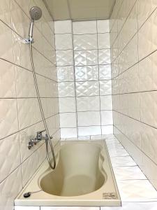 a bath tub in a tiled bathroom with a shower at Haus 19 in Puli