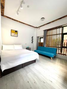 a bedroom with a bed and a blue couch at Haus 19 in Puli
