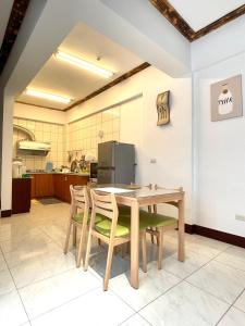 a dining room with a table and chairs and a kitchen at Haus 19 in Puli +17 photos