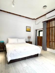 a bedroom with a large bed with white sheets at Haus 19 in Puli