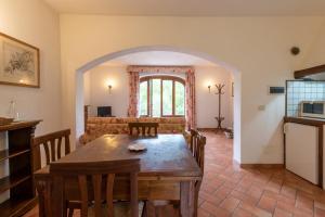 een keuken en een woonkamer met een tafel en een bank bij Casale Falco Grande in Chiusi della Verna