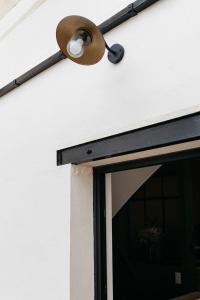 a lamp on the side of a building with a window at Avenue Ferry in Libourne