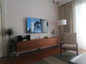 a living room with a television on a wall at Timeless Ambassador -Belém in Lisbon