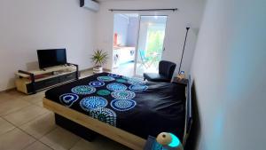 1 dormitorio con 1 cama con edredón negro en Studio confort avec jardinet, en Montjoly