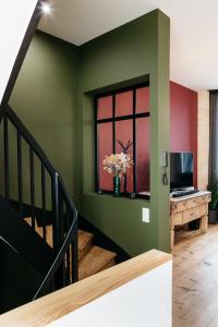 a staircase with a green wall and a window at Avenue Ferry in Libourne