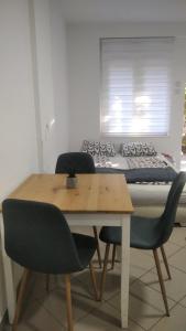 a dining room table with two chairs and a bed at Apartman 5 - Studio Ristić in Soko Banja