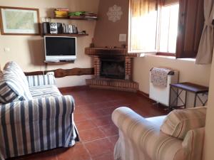 sala de estar con 2 sofás y chimenea en Casa Los Maestros, en El Arenal