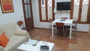 sala de estar con sofá y mesa con sillas en Las Torres, en Cuenca