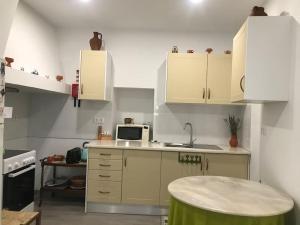 a small kitchen with white cabinets and a sink at Casa do Reguengo 1 in Estremoz