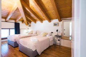 - 2 lits dans une chambre dotée de plafonds en bois dans l'établissement Casa Agatha, à Lenno