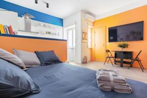 a bedroom with a blue bed and a flat screen tv at Vaticano & Villa Pamphilj Studio in Rome