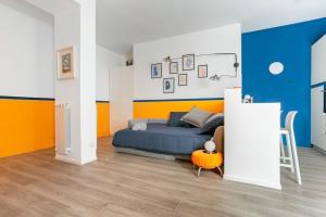 a bedroom with a blue bed and orange walls at Vaticano & Villa Pamphilj Studio in Rome