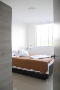 a bed in a room with a window at INCREIBLE APARTAMENTO Puerto Azul Club House RICAURTE in Ricaurte