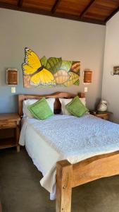 um quarto com uma cama com uma borboleta na parede em Pousada Fecho da Serra em Capitólio