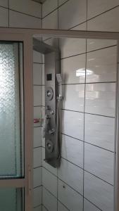 a shower in a bathroom with a glass wall at The FFG House - Appartements meublés Douala Cite des palmiers, Bonamoussadi in Douala