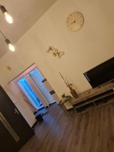 a living room with a door and a clock on the wall at The FFG House - Appartements meublés Douala Cite des palmiers, Bonamoussadi in Douala