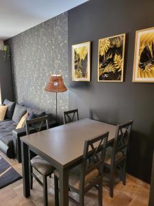 a dining room with a table and chairs and a couch at Moon Apartments Poznań in Poznań