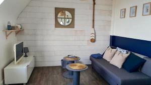 - un salon avec un canapé bleu et une table dans l'établissement Vue Sur Mer, à Port-en-Bessin-Huppain