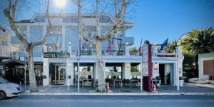 滨海弗兰卡维拉科拉罗酒店的一座白色建筑，前面摆着桌椅