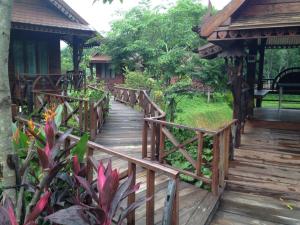 a wooden walkway leading to a gazebo at Burilamplai Resort บุรีลำปลาย รีสอร์ท in Thung Yai