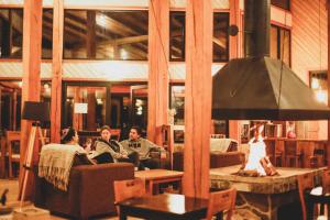 a group of people sitting in a living room with a fireplace at MI Lodge Las Trancas Hotel & Spa in Las Trancas