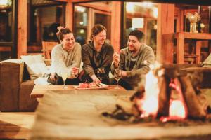 eine Gruppe von Menschen, die an einem Tisch sitzen und Wein trinken in der Unterkunft MI Lodge Las Trancas Hotel & Spa in Las Trancas