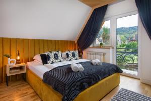 a bedroom with a bed with two towels on it at Rezydencja Skibówki in Zakopane