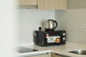 The Palm, 2BR Cityview by WStay @ Tropicana 218 Macalister في جورج تاون: وجود ميكروويف للجلوس على طاولة المطبخ