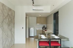 The Palm, 2BR Cityview by WStay @ Tropicana 218 Macalister في جورج تاون: مطبخ مع طاولة وكراسي حمراء في الغرفة