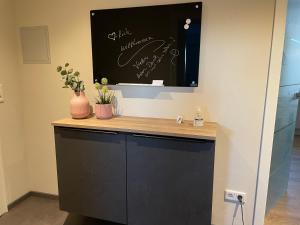 a black cabinet with a wooden counter with plants on it at Lieblingsplatz-Winterberg in Winterberg