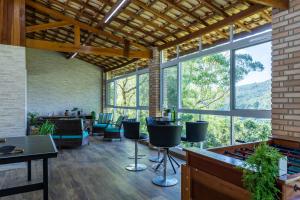 マイリポランにあるChácara 8 suítes Piscina Churrasqueira 40min de SPの大きな窓、テーブル、椅子が備わる客室です。