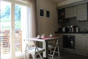 a kitchen with a table and two chairs and a counter at La Vita in Campagna in Villa di Tirano