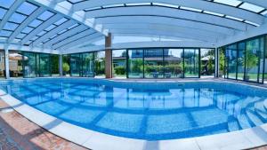uma piscina num edifício com tecto de vidro em NEW! Suite Apartment em Castelnuovo del Garda
