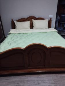 a large wooden bed with two pillows on it at Balti house in Bălţi