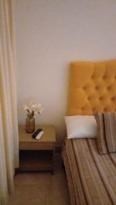 Un dormitorio con una cama y una mesa con un jarrón de flores en Apartamento Turístico Frailejones, en Duitama