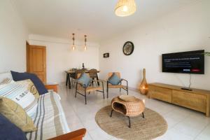 a living room with a bed and a tv at Apartamento Sea Shell in Albufeira